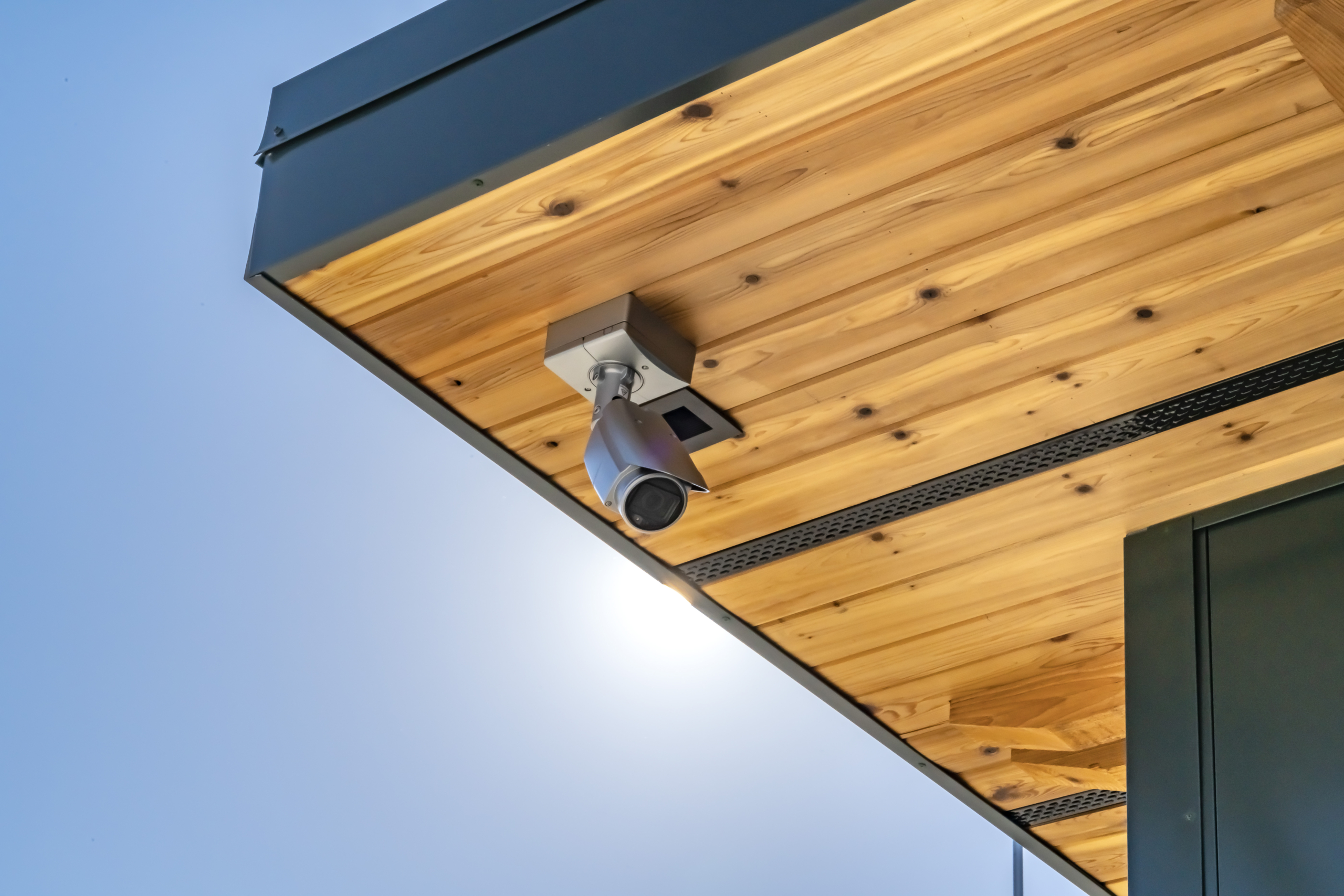 Home with security camera installed on the wooden underside of its roof